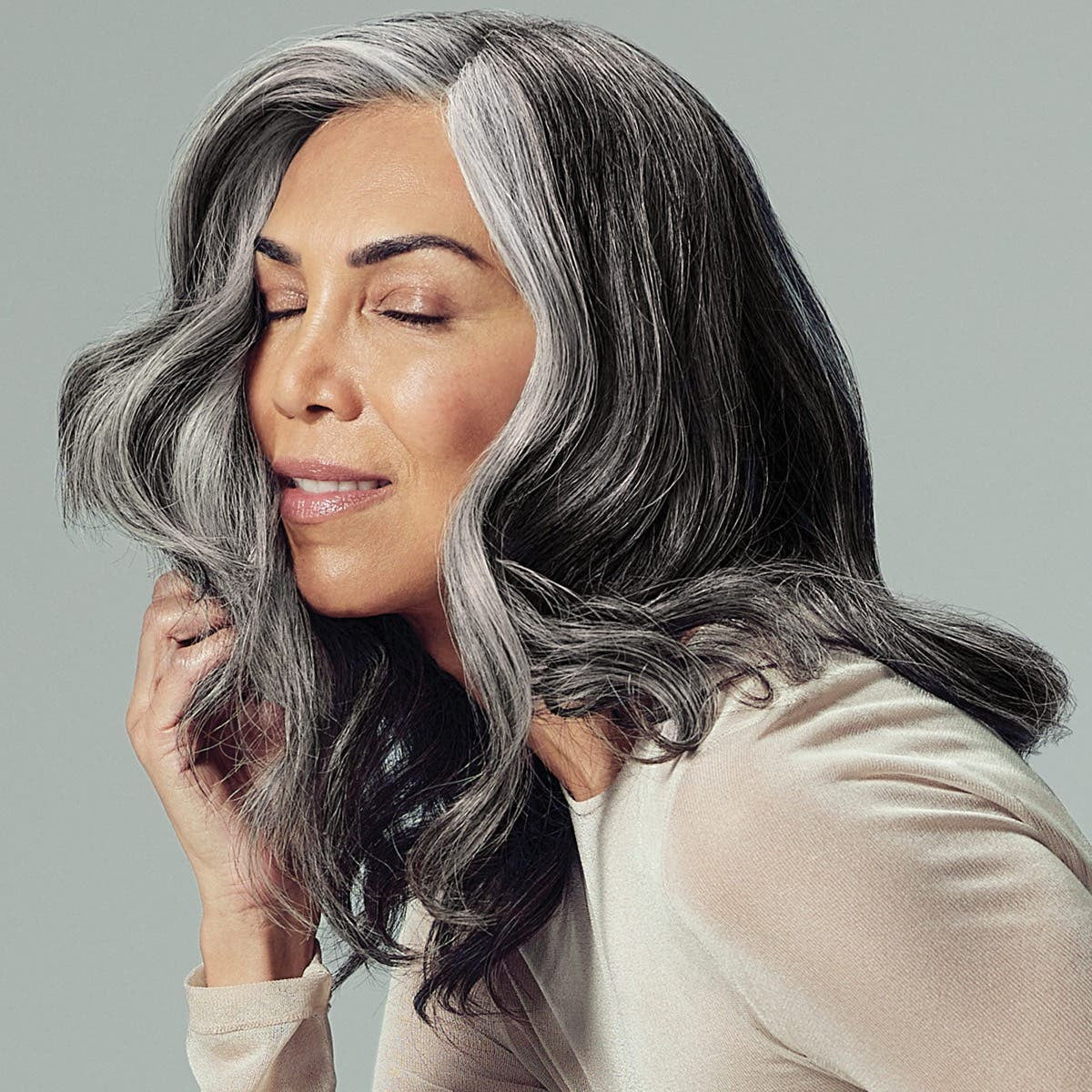 Model with voluminous styled hair using Paul Mitchell Extra-Body Firm Hairspray